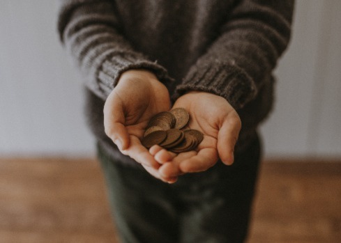 Picture of a person holding coins. The image symbolises Elorn's blog about a cashless society.