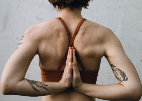 Picture of a human yogi with hands behind their back in a stretch. The picture symbolises Elorn's blog post about wellness.